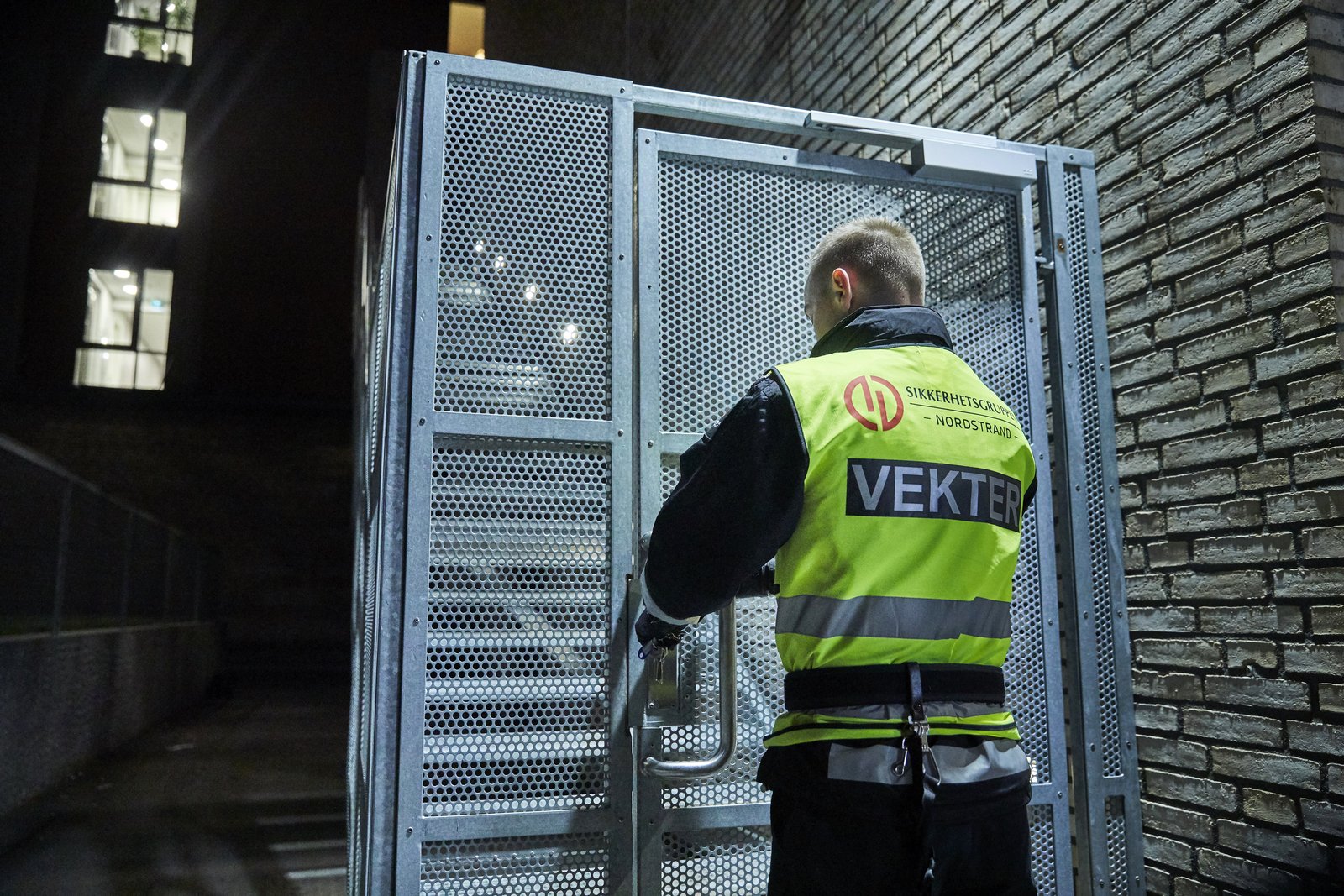 Vekter fra Sikkerhetsgruppen kontrollerer en port i et fellesareal